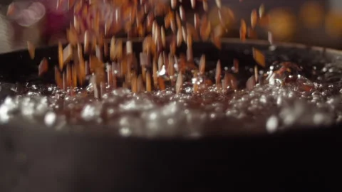 Red rice grains falling in boiling water Stock Footage 135049031