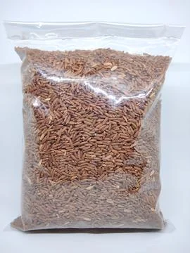 Red rice inside plastic isolated in white background Stock Photos