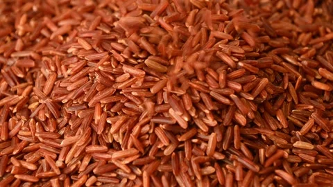 Red rice pouring and settling into pile Stock Footage 331592528