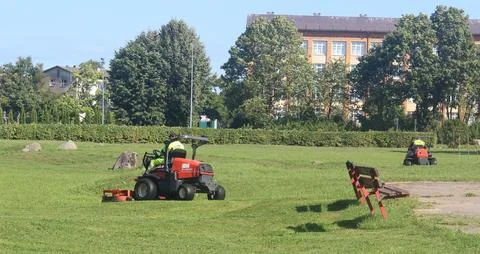 Red Riding Lawn Mower Operator Performing Grass Maintenance Stock Photos