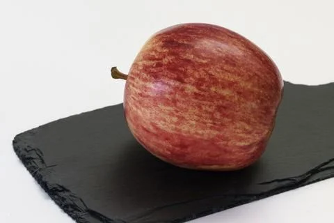 Red ripe apple on a cutting graphit board. Stock Photos
