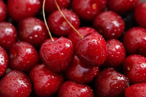 Red ripe cherry fruit background, two cherries on top Stock-Fotos