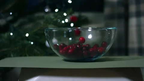 Red ripe cranberries dropping in a bowl Christmas tree light background Stock Footage 325448651