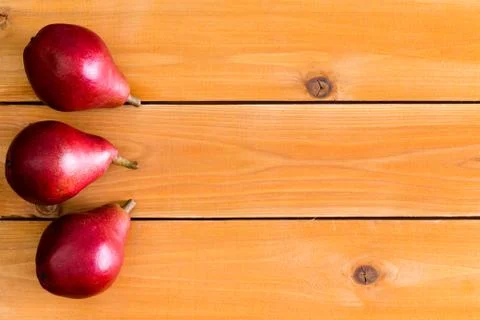 Red ripe pears on one side of table surface Stock Photos