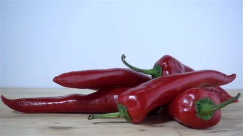 Red ripe peppers falling in slow motion Stock Footage 126607968