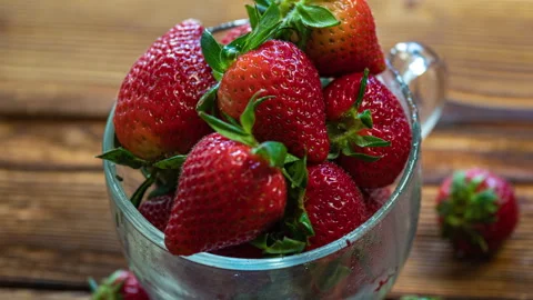 Red ripe strawberries in a cup rotating on a wooden table. Juicy Fresh Ripe Stock Footage 273198910