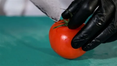 Red ripe tomato cut in half by the chef's culinary knife Stock Footage 75394638