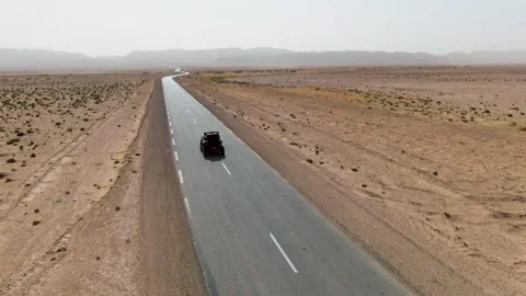 Red Off-Road Buggy Speeding on Desert Asphalt Road With UTV Alongside Arid Stock Footage 332204570