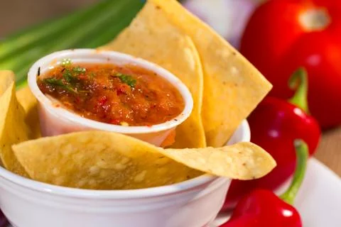 Red roasted tomato salsa with corn chips. Stock Photos