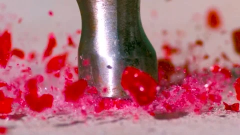 Red rock candy being crushed and broken by a hammer in slow motion. After Stock Footage 283944751
