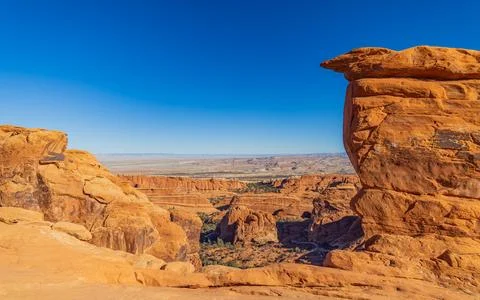 Red rock formations frame a vast desert canyon view. Stock Photos