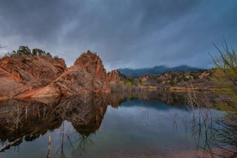 Red rock formations reflected in a calm lake. Stock Photos