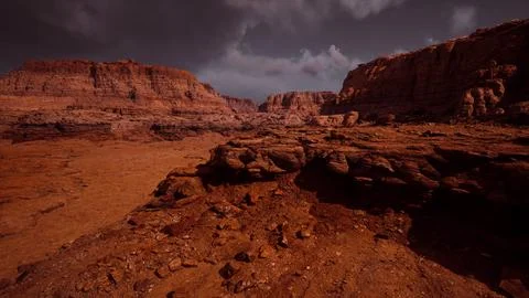 Red rock formations under a dramatic sunset sky in the desert Stock Illustration