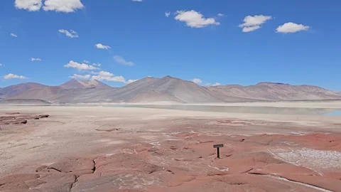 Red Rock Plain with Marker and Blue Mountains, Piedras Rojas, Atacama, Chile 8K Stock Footage 331539692