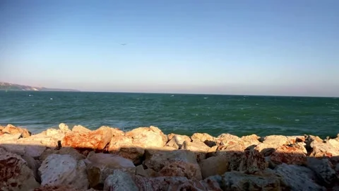 Red Rocks In The Sea. Large Piece Of Rock On Sea. Colored Stones On The Beach. Stock Footage 151261406