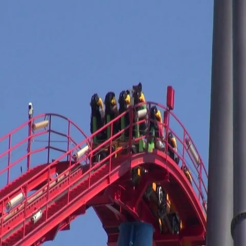 Red roller coaster ride on an amusement park climbs Vídeos de archivo 69734101