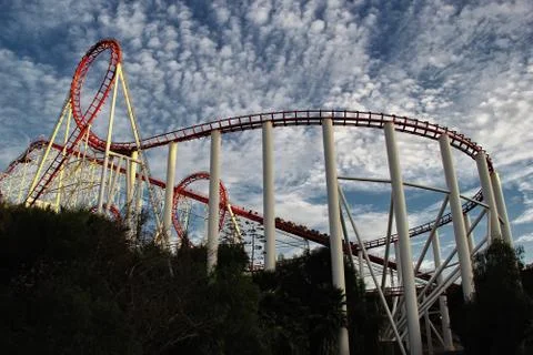 Red roller coaster track with a dark cloudy sky Stock Photos