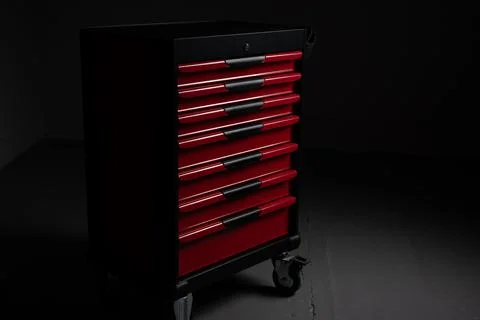 Red rolling tool cabinet in dark workshop garage Stock Photos