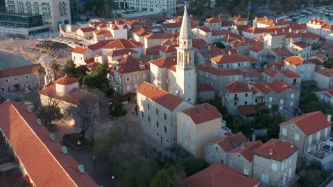 Red roofs on white medieval stone houses featuring church bell tower Stock Footage 167578076
