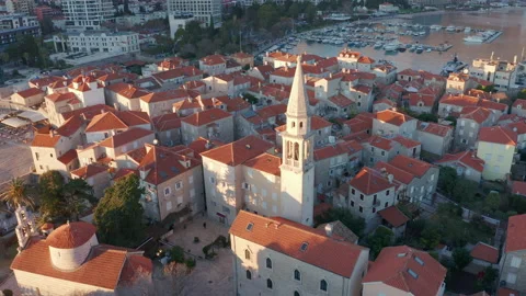 Red roofs on white medieval stone houses featuring church bell tower Stock Footage 167618256