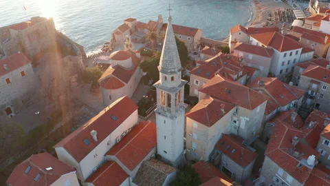 Red roofs on white medieval stone houses featuring church bell tower Stock Footage 167619664