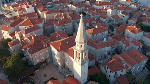 Red roofs on white medieval stone houses featuring church bell tower Stock Footage 167621051