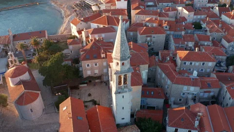 Red roofs on white medieval stone houses featuring church bell tower Stock Footage 167622952
