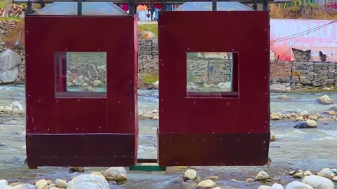 Red ropeway situated above the flowing river 스톡 동영상 148254317