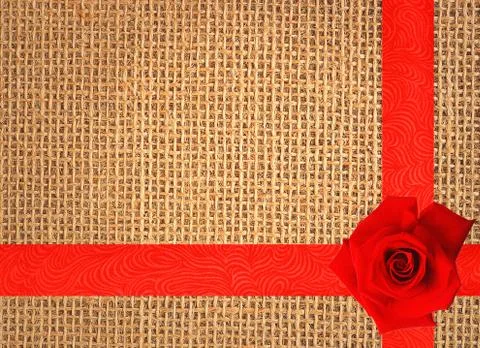 Red rose on linen texture background with red ribbon 库存照片