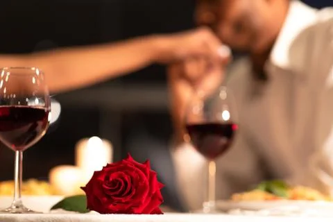 Red Rose Lying On Table, Man Kissing Woman's Hand Indoor Stock Photos
