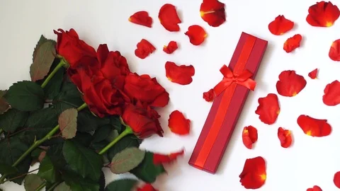 Red roses and present box on white table. Slow motion. Holiday background. Stock Footage 102836603