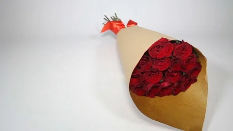 Red roses bouquet in paper package. left to right Stock Footage