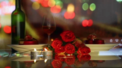 Red roses, candles in table setting with wine glass and bottle. blurred color Stock Footage 148359832