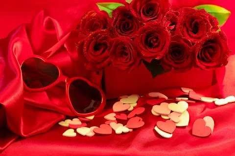 Red roses in a gift box on red background with pink and white hearts scattered Stock Photos