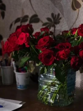 Red Roses in a Jar on a Work Table Stock Photos