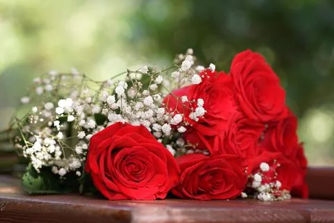 Red roses with white decorative elements on bouquet thats on table Foto stock