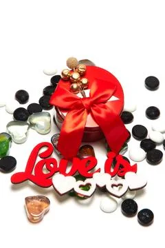 Red round box with a bow and decoration on top, the inscription love is, wh.. Stock Photos