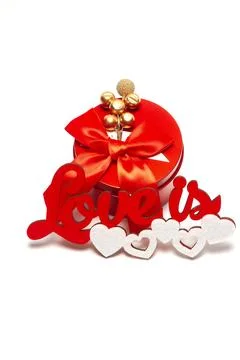 Red round box with a bow and the inscription love is with white hearts on a.. Stock Photos