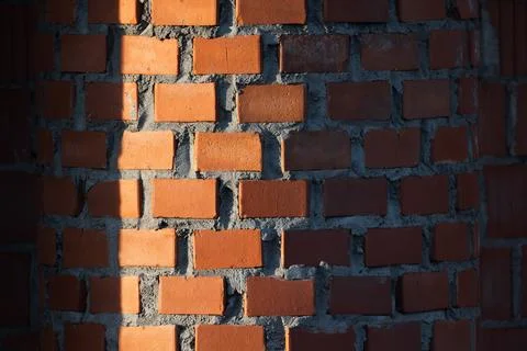 Red round brick wall pattern with deep shadows Stock Photos