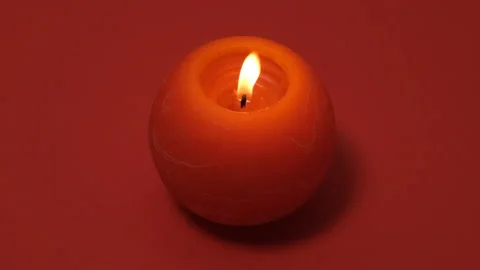 Red round burning candle isolated on red background. 4k resolution video banner Stock Footage 170339000