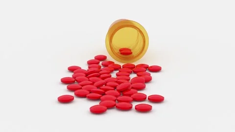 Red round pills scattered on the table from a yellow jar Stock Footage 162339448