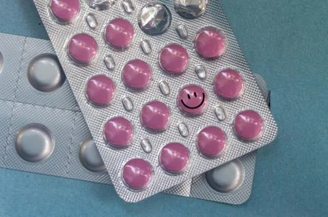 Red round tablets smile in a package on a blue background Stock Photos