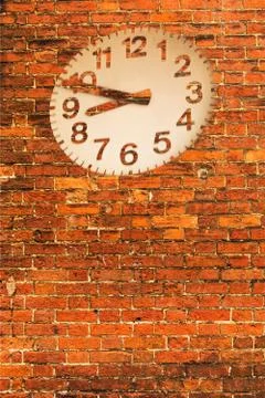 Red round wall clock on brick wall Stock Photos