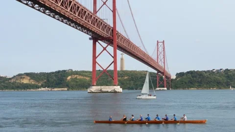 Red rowing boat with a team of rowers glides along the river Stock Footage 310677148