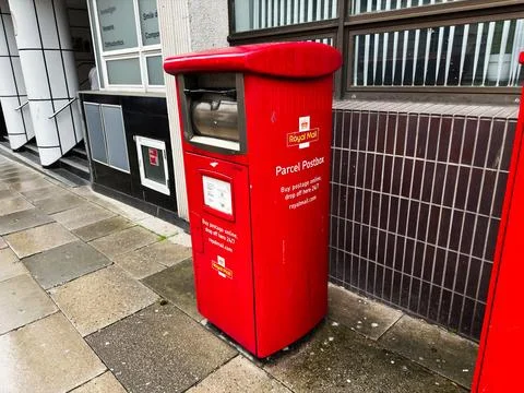 Red Royal Mail parcel postbox on a wet Liverpool, UK street outside commerc.. Stock Photos