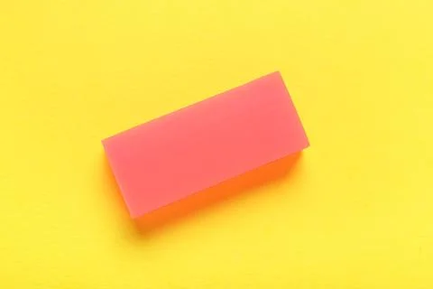 Red rubber eraser on yellow background Stock Photos