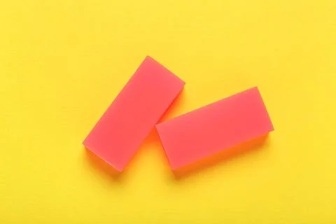 Red rubber erasers on yellow background Stock Photos
