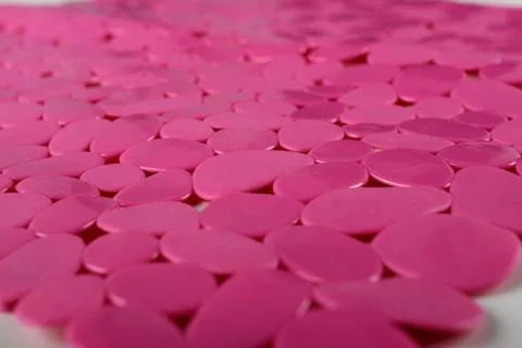 Red rubber mat for bath with pattern as background, imitation of river stone Photos
