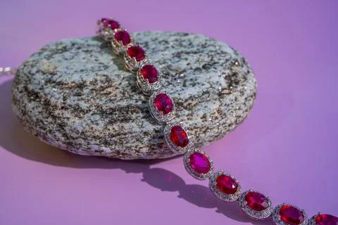 Red Ruby bracelet with diamonds on the glittering stone. Pink background Stock Photos