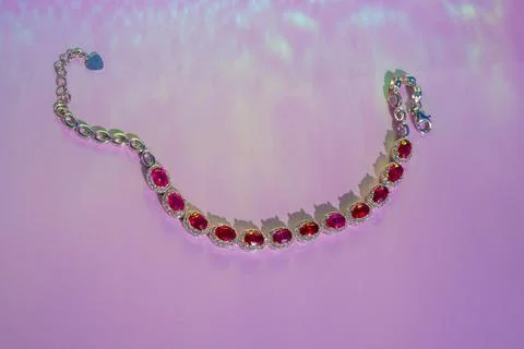 Red Ruby bracelet with diamonds on the glittering pink background Stock Photos